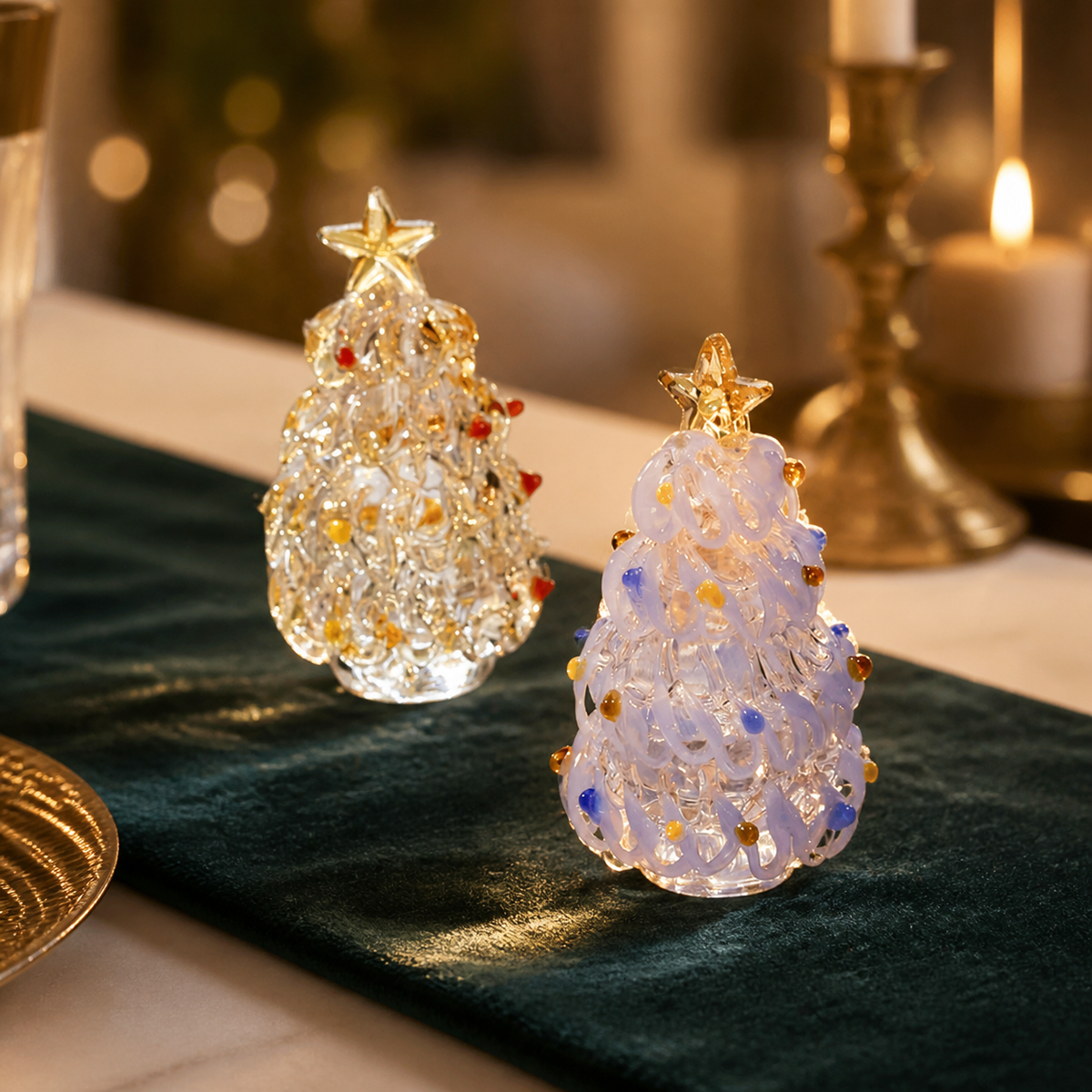 Clear gold and icy white glass Christmas tree figurines on a forest green holiday table