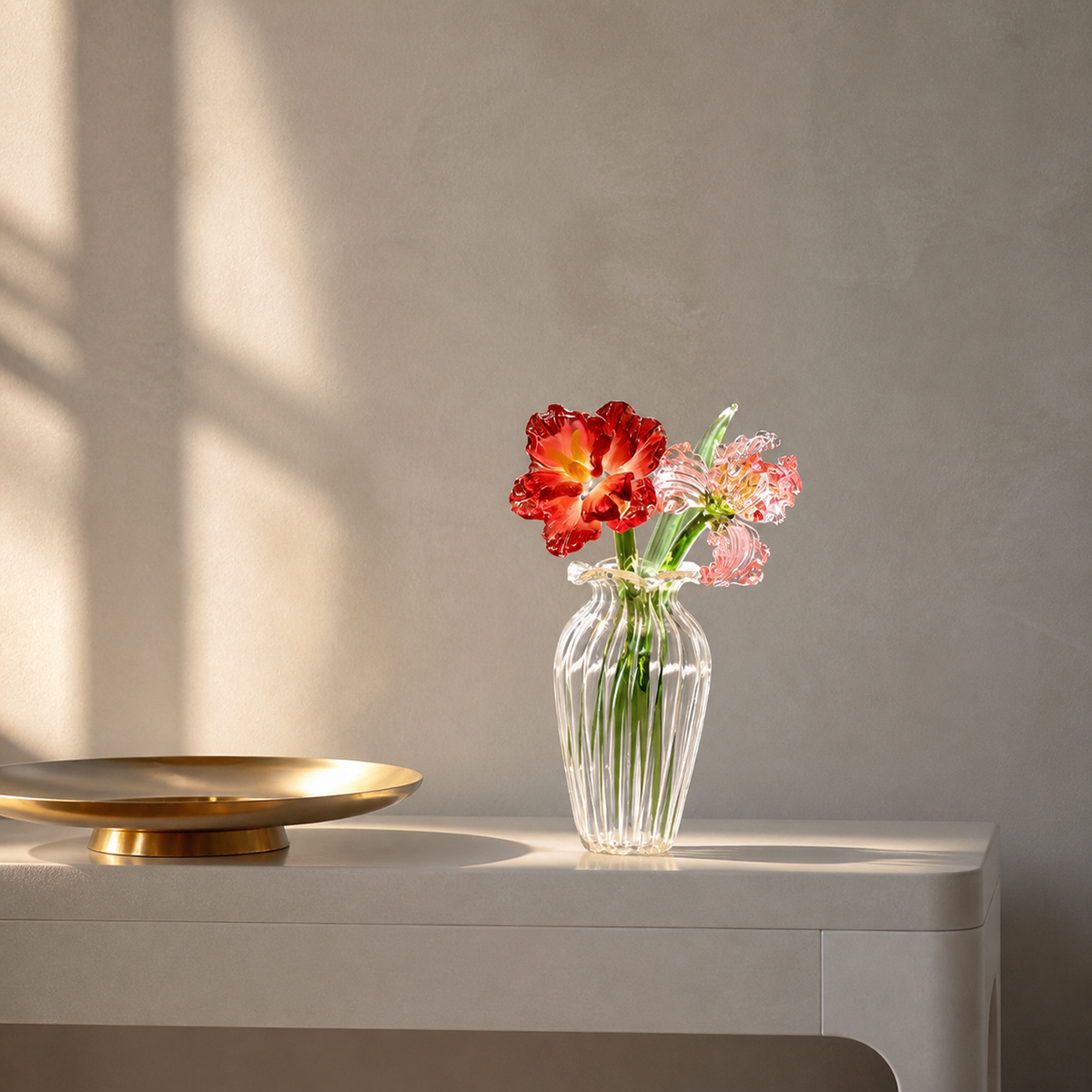 Red peony and pink iris glass flowers in a ribbed vase on a console